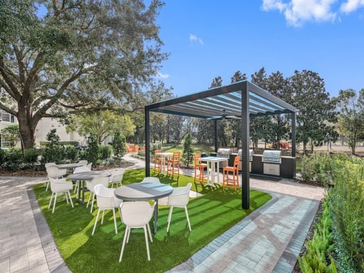 a patio with tables and chairs under a canopy