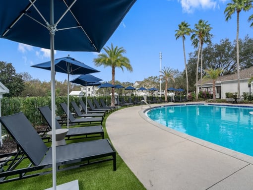 a swimming pool with lounge chairs and umbrellas at the resort