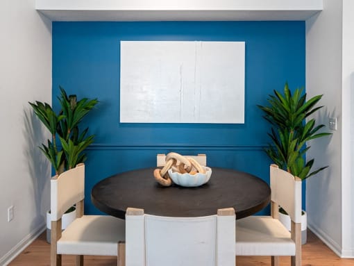 a dining room with a blue wall and a table and chairs