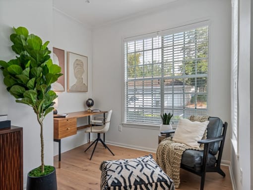 a living room with a couch and a desk and a window