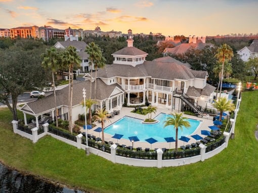 an aerial view of a mansion with a large swimming pool