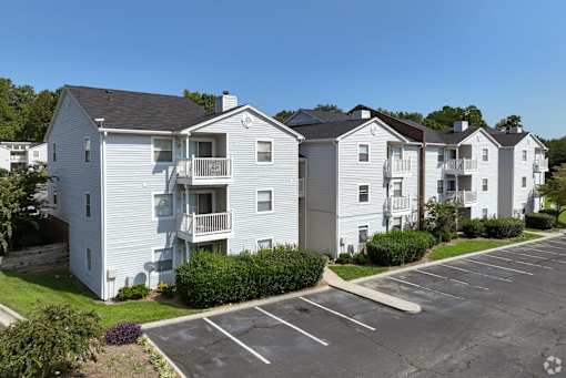 A row of white apartment buildings with a parking lot in front at Sedgefield Square Apartments, Greensboro, 27407