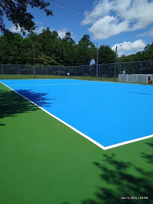 A blue and green tennis court with a timestamp in the corner at Sedgefield Square Apartments, North Carolina