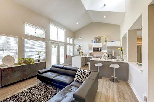 A modern living room with a black couch and a wooden cabinet at Sedgefield Square Apartments, Greensboro