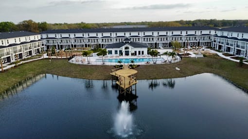 A large building with a pool and a dock in front of it.