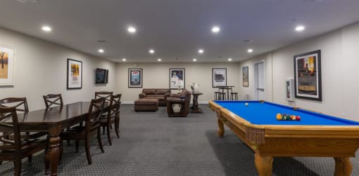 a game room with a pool table and chairs