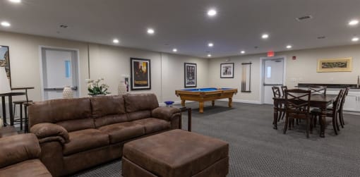a basement with a pool table and couches