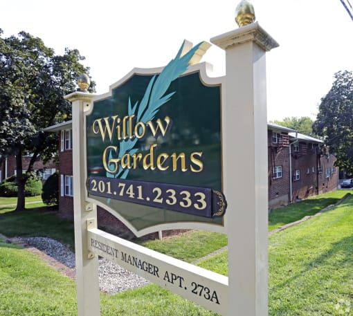 a sign in front of a building that says willow gardens