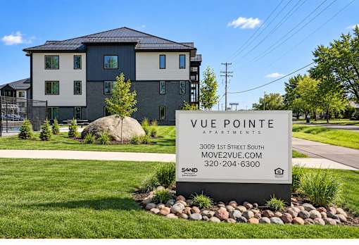 A sign in front of a building that says "Vue Pointe Apartments".
