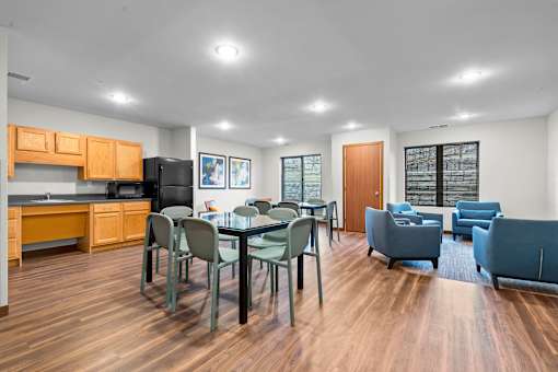 A kitchen with a dining table and chairs.