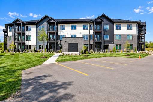 A large multi-story building with a parking lot in front.