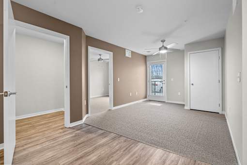 A living room with a ceiling fan and a window with blinds.