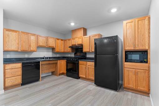 a kitchen with black appliances and wooden cabinets