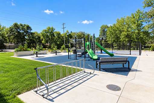 A playground with a slide and a bench.