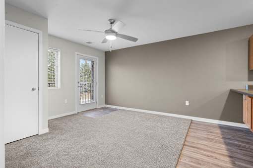 A living room with a ceiling fan and a carpeted floor.