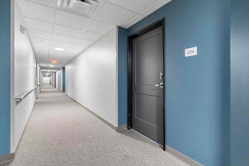 a hallway with blue walls and a door in a building