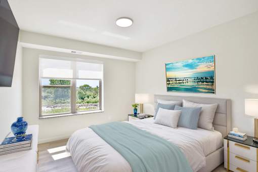 A bedroom with a large bed and a painting on the wall.