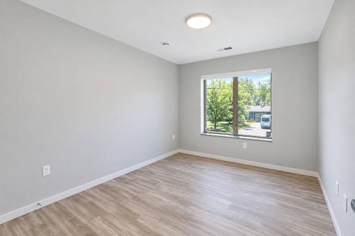 A room with a window and wooden flooring.