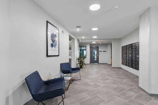 a corridor with two chairs and a table in a building