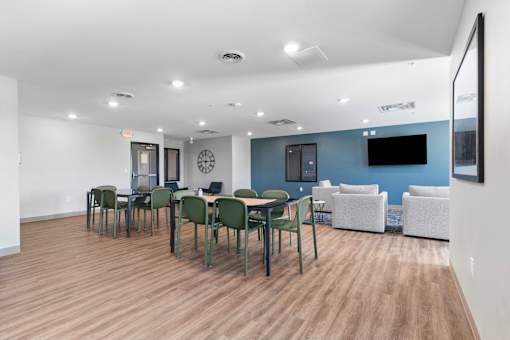 a dining room with tables and chairs and a tv on the wall