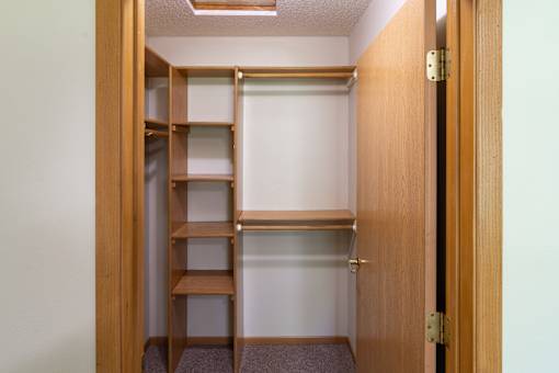 A small closet with shelves and a door.