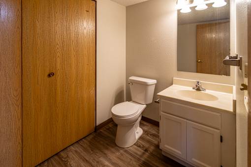 A white toilet sits in a bathroom next to a sink.