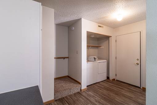 A small room with a washing machine and a door.