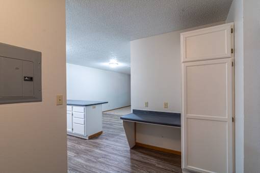 A kitchen with a blue countertop and white cabinets.