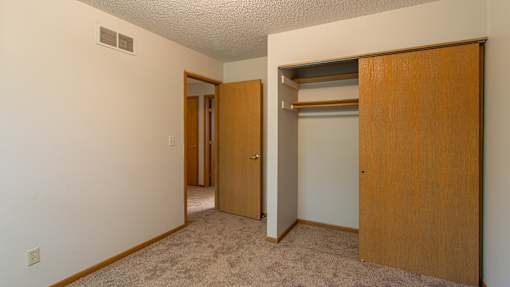 A room with a carpeted floor and a sliding door.