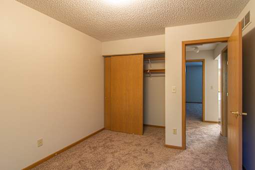 A room with a carpeted floor and a wooden door.