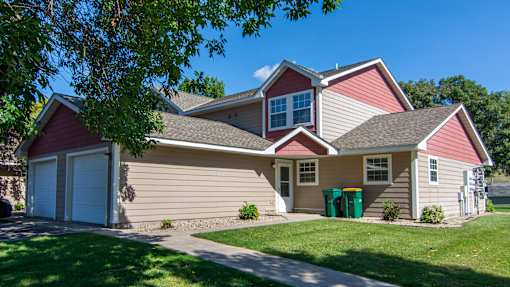 A house with a red roof and a white garage door.