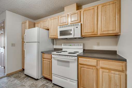 A kitchen with wooden cabinets and white appliances.