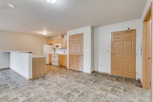 A kitchen with vinyl flooring and a counter.