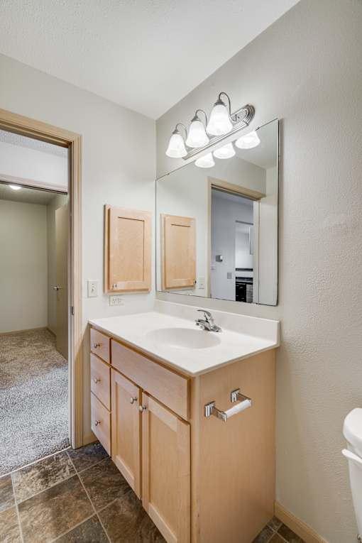 A bathroom with a sink, mirror, and light fixture.