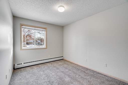 Primary Bedroom with a window and carpeted floor.