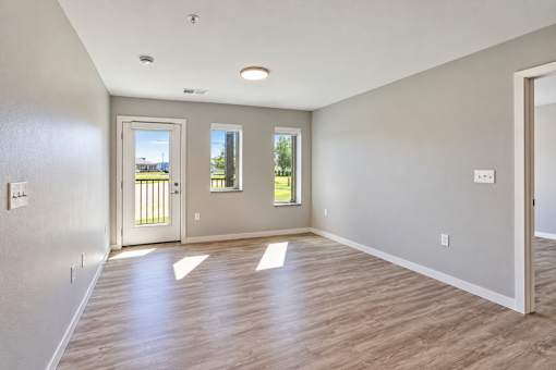 A room with wooden flooring and a door leading outside.