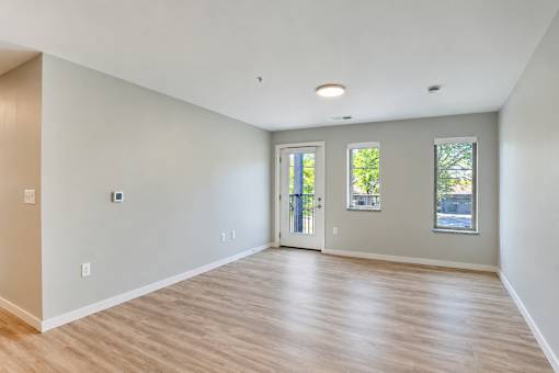 A room with wooden flooring and white walls.