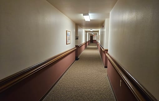 A long hallway with a carpeted floor and white walls.