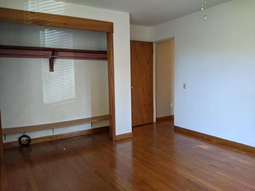 A room with a wooden floor and a sliding door.