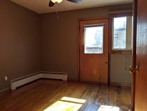 A room with a brown wall and a ceiling fan.