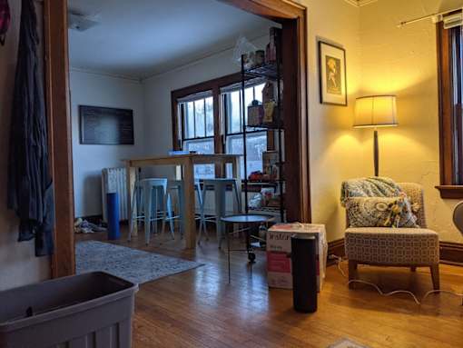 A room with a chair and a table in it.