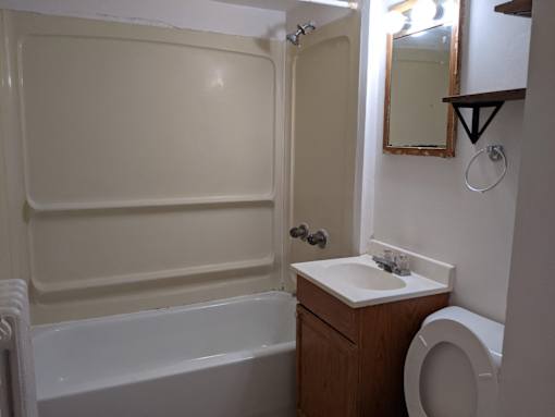 A white bathroom with a toilet, sink, and bathtub.
