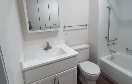 A white bathroom with a toilet, sink, and bathtub.