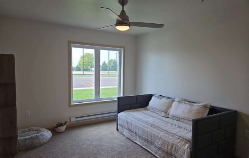 a bedroom with a bed and a ceiling fan