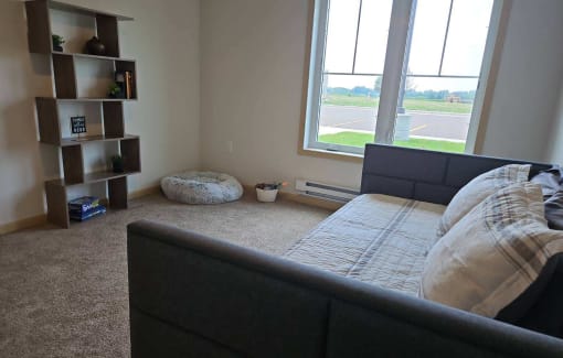 a bedroom with a bed and a large window