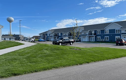 A street view of a residential area with houses and cars.