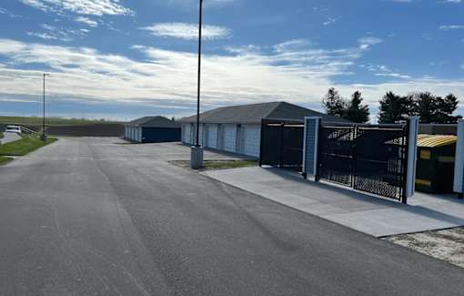 A long, paved road leads to a row of garages.