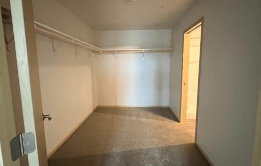 an empty room with a door to a closet