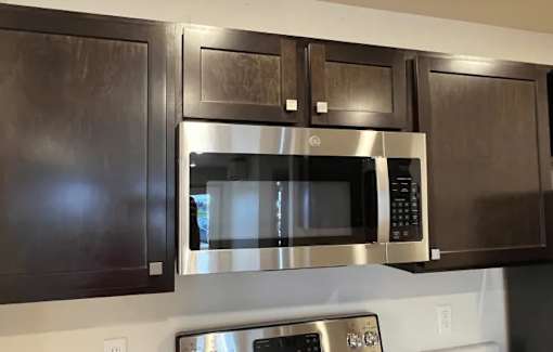 a microwave oven in a kitchen with black cabinets