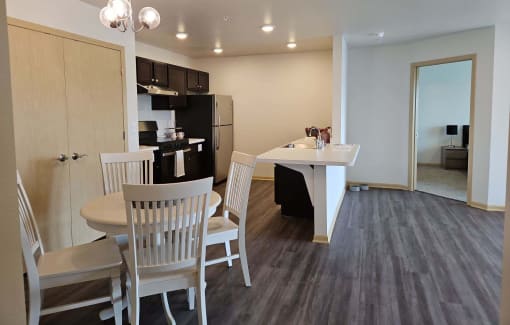 a dining room and kitchen with a table and chairs